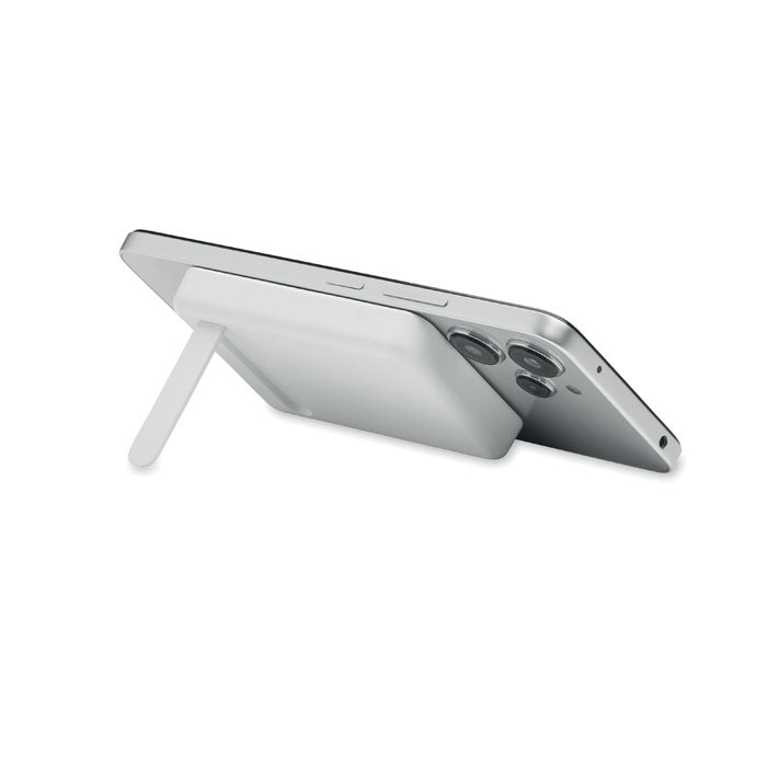 ATLAS - Powerbank magnético 5000mAh apoyado en un móvil con soporte incluido.