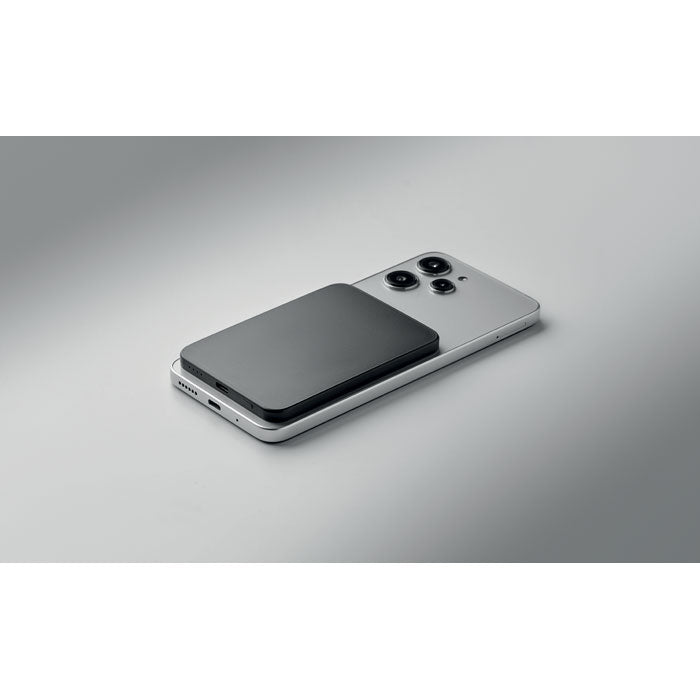 SLIMVOLT - Powerbank ultrafino de 20 W sobre un teléfono inteligente en una superficie gris
