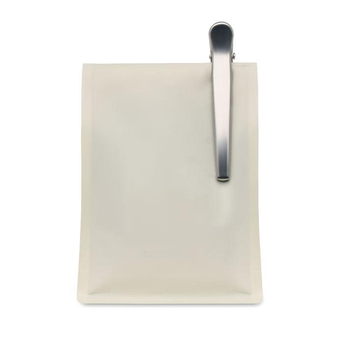 SPOONCOOP - Cuchara con clip para bolsa sobre una bolsa blanca con un clip de acero inoxidable.