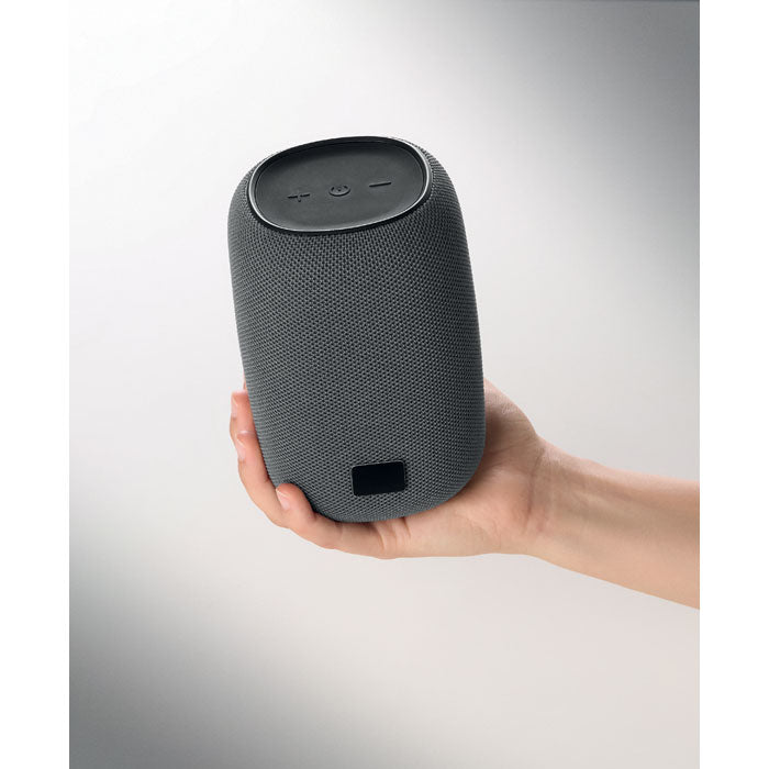 Mujer sosteniendo el TOAVOLT - Altavoz inalámbrico de 8 W con diseño moderno y tejido PET.