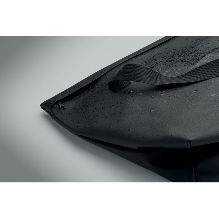 RIDE TOTE BAG - Bolsa de PU para bicicleta 10L, detalle del material repelente al agua en color negro.