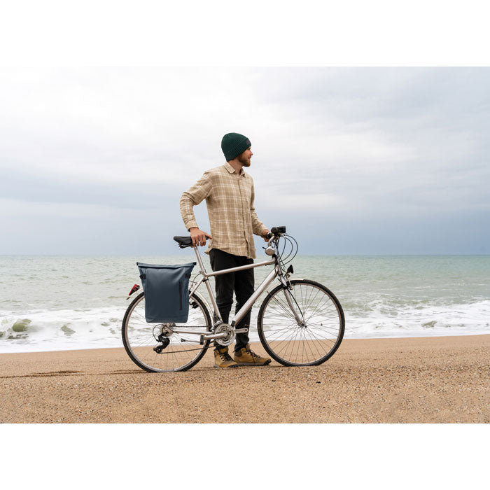 Hombre con mochila RIDE BACKPACK - Mochila PU para portátil 20L en bicicleta frente al mar