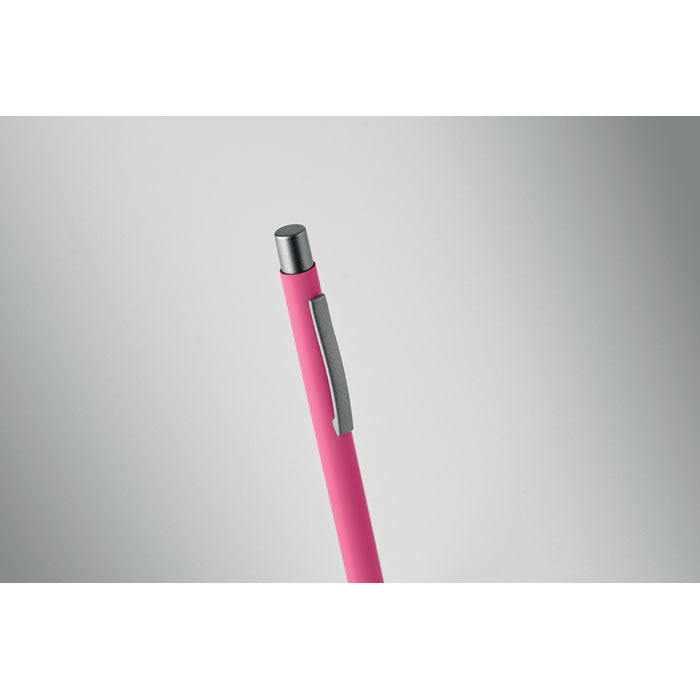 Bolígrafo reciclado de aluminio en color rosa con acabado engomado y clip gris antracita.