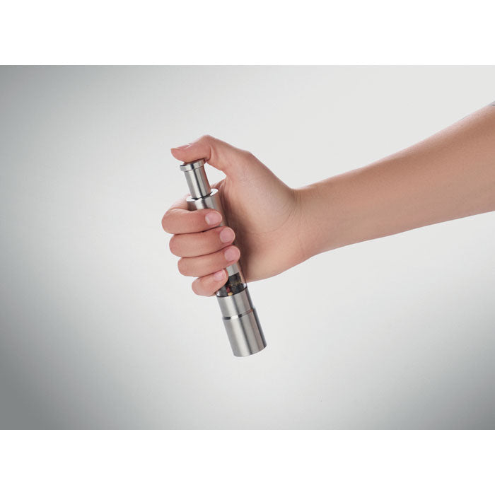 Mano utilizando el PRESSY - Triturador de sal o pimienta, herramienta de cocina moderna y elegante.