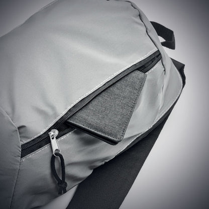 Bolsillo exterior de mochila reflectante gris con cierre de cremallera con una cartera en su interior 