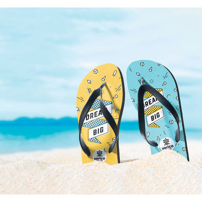 Foto de arena de playa con chanclas blancas