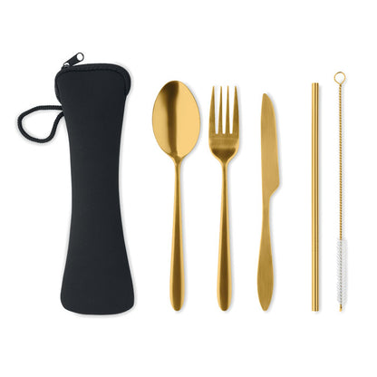 Cuchara, tenedor, cuchillo, pajita dorados y cepillo alineados junto a la funda.  