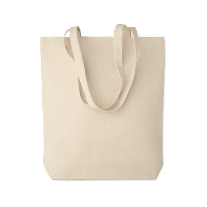 Bolsa tote RASSA de canvas con fuelle vista frontal, perfecta para uso diario y eventos promocionales. Fabricada en algodón ecológico de alta densidad.