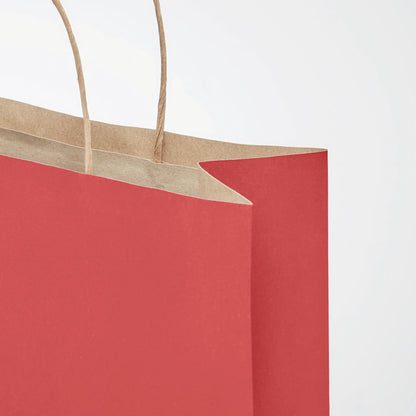 Detalle de bolsa de papel con el exterior de color rojo e interior de color kraft y asas retorcidas