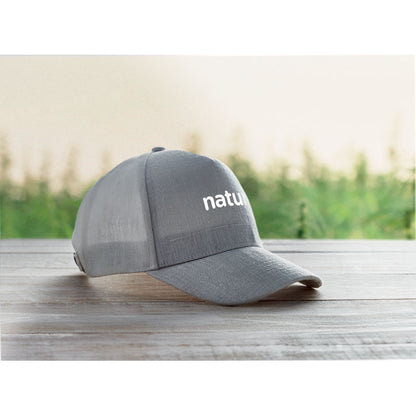 Gorra gris promocional personalizada con logotipo en panel forntal  sobre una superficie de madera
