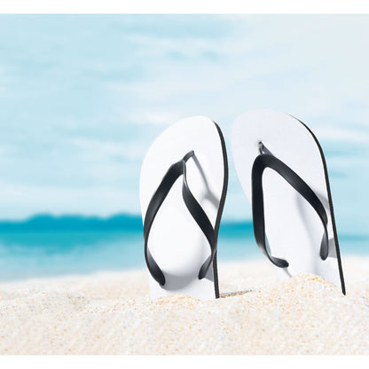 Arena en la playa con 2 chanclas clavadas blancas