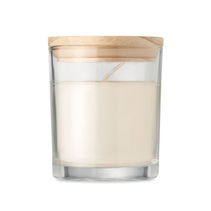 Vela con envase de cristal y tapa de bambú. Caja blanca cilíndrica al lado