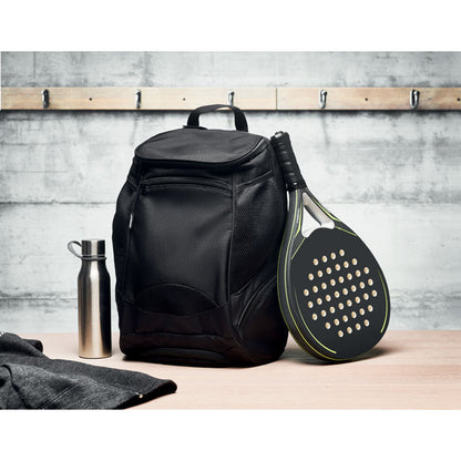 mochila de deporte negra grande junto a botella de metal y sobre la que apoya una raqueta de pádel