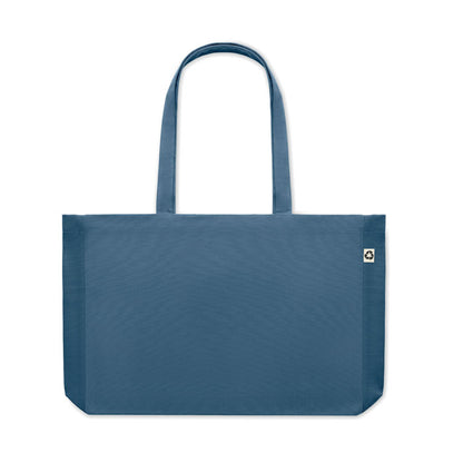 Bolsa de algodón azul con asas largas y fuelle y con etiqueta de algodón orgánico cosida en un lateral