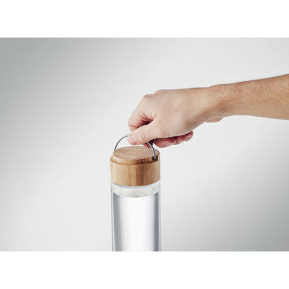 Mano abriendo tapón de bambú de botella