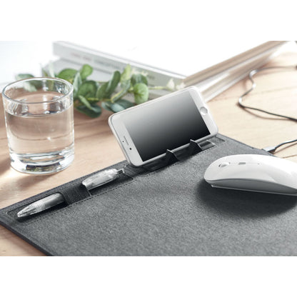 Alfombrilla de escritorio con bolígrafo, ratón y teléfono móvil en mesa de oficina