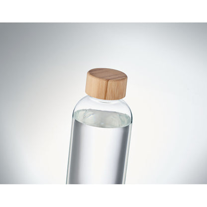 Agua dentro de botella de cristal con fondo gris