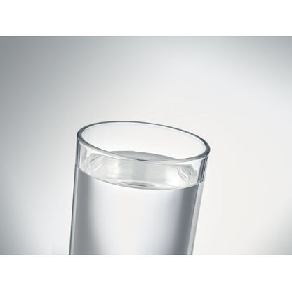 Vaso de cristal lleno de agua sobre fondo gris neutro