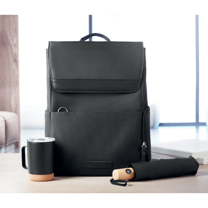 Mochila negra de RPET con paraguas sobre mesa de madera