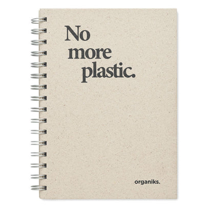 Detalle de libreta con boli sobre mesa de madera