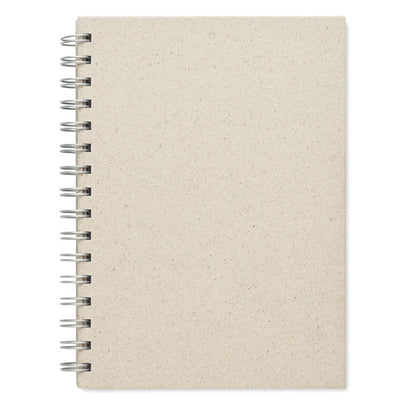 Cuaderno abierto con hojas de hierba