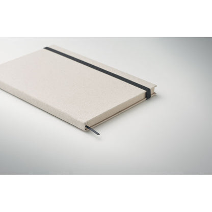 Vista lateral de libreta beige con cierre elástico fondo gris
