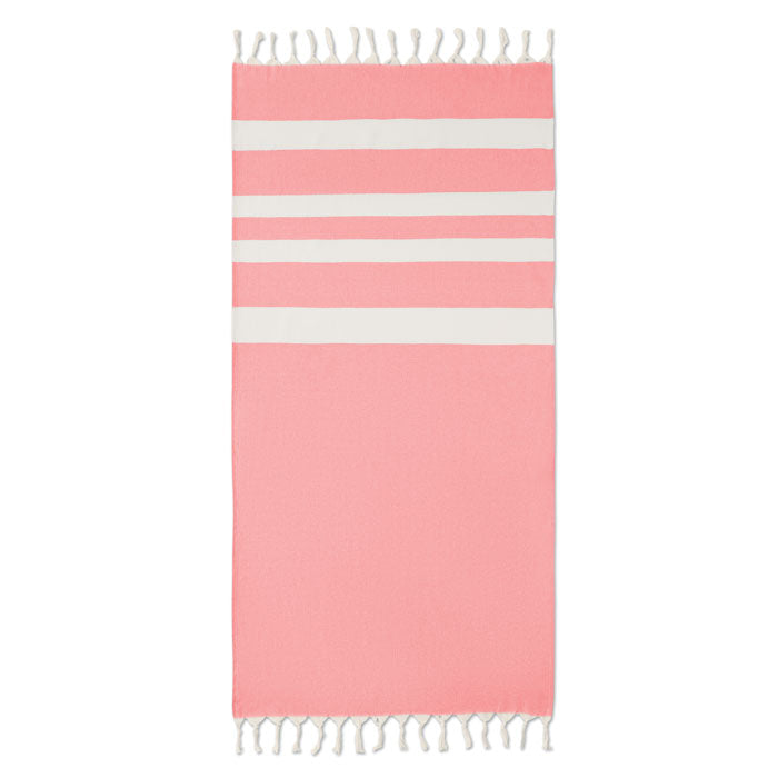 Toalla de playa en color rosa con franjas blancas y borlas, ideal para un día soleado. Características de AGOURA - Toalla de playa/pareo 140gr/m².