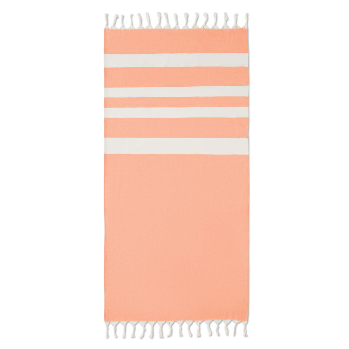 Toalla de playa naranja con franjas blancas y flecos, ideal para verano y actividades al aire libre. AGOURA - Toalla de playa/pareo 140gr/m².