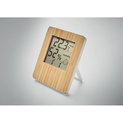 Estación meteorológica de madera de bambú con pantalla con reloj, indicador de temperatura, humedad relativa y calendario sobre fondo neutro gris