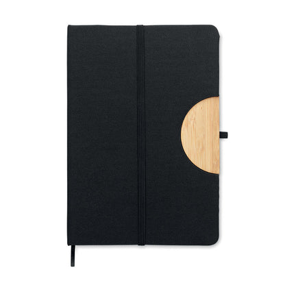 Vista superior de libreta negra con bambú