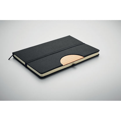 Libreta negra con detalles de bambú y cierre goma. Fondo gris
