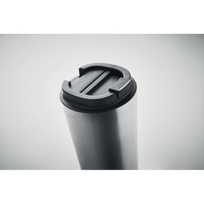 Detalle de tapa negra antifugas de vaso de acero sobre fondo gris