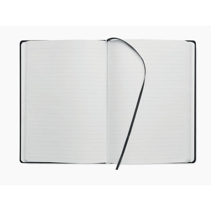 Libreta A5 abierta con hojas rayadas y cinta de tela para marcar las páginas