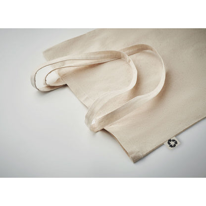 Detalle de asas largas y etiqueta con símbolo de tejido reciclado en totebag