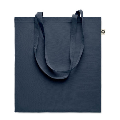 Detalle de asas largas y etiqueta de tejido reciclado en tote bag roja