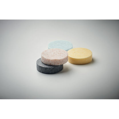 Pastilla de jabón, champú, exfoliante y barra micelar sobre fondo neutro