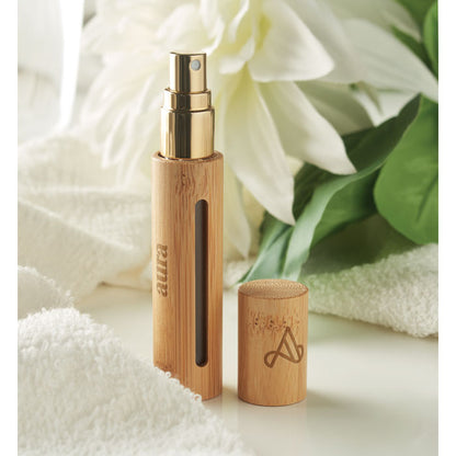 Spray para perfume sobre mesa blanca con tapa y logo