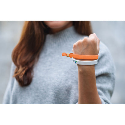 Brazo de chica con 2 pulseras naranja  blanca