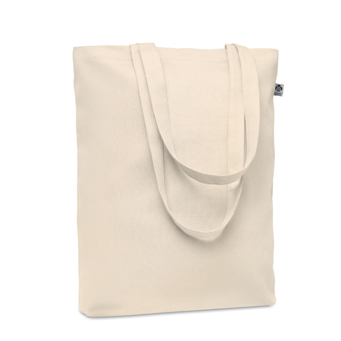 Bolsa de canvas orgánico color beige con asas largas y fuelle inferior, vista posterior.