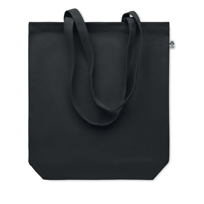Bolsa negra de canvas con pequeña etiqueta de algodón orgánico cosida en el lateral y asas largas