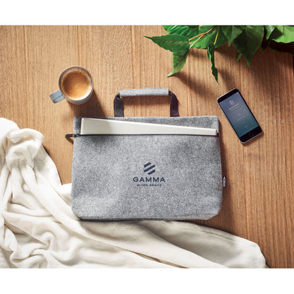 Funda de portátil gris con logo, taza y móvil en mesa de madera