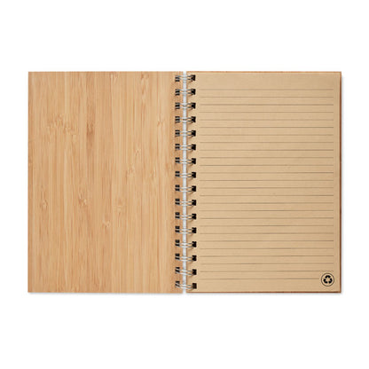 Cuaderno abierto de madera con hojas ecológicas