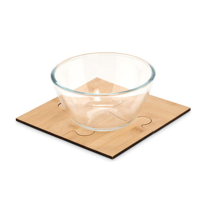 Cuenco de cristal sobre 4 posavasos con forma de pieza de puzle encajados