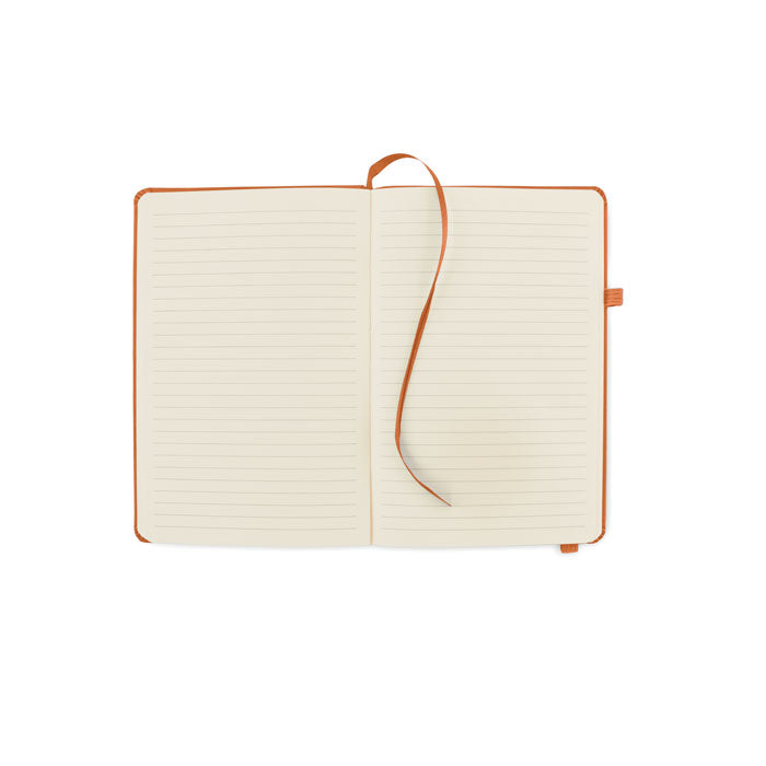 Vista superior de una libreta abierta con páginas rayadas y cinta marcador en color marrón, ideal para notas y escritura.