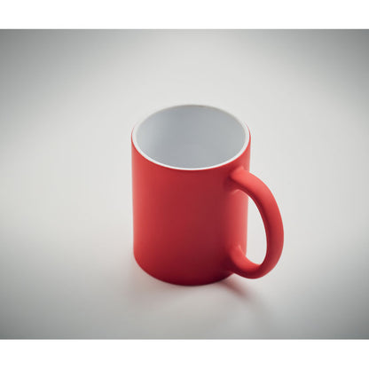 Vista superior de taza de cerámica blanca con revestimiento exterior rojo mate