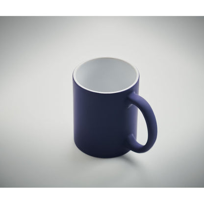 Vista superior de taza de cerámica blanca con revestimiento exterior azul mate