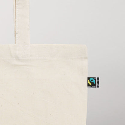 Detalle de pequeña etiqueta con logotipo de algodón fairtrade cosida en el lateral de la bolsa