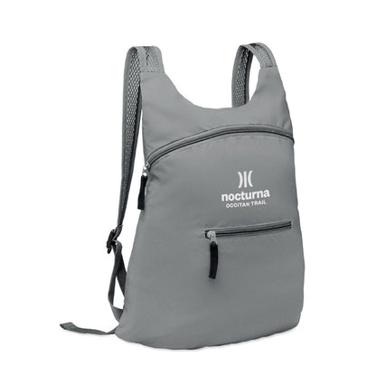 Mochila gris reflectante plegable en su propio bolsillo frontal con cremallera y personalizada con logotipo en parte frontal