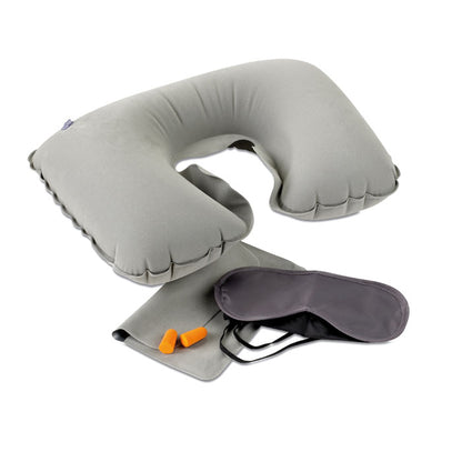 Set de viaje gris con almohada inflable, antifaz y tapones sobre fondo blanco