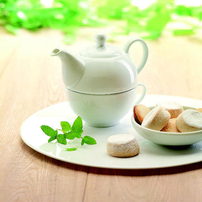 Tetera y taza en una mesa de madera con merienda